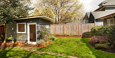 A shed sits in a lush, green yard.